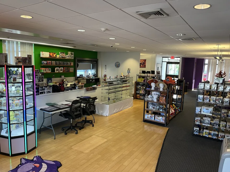 Wood floor and purple walls at Thousand Sunny, with figure shelves along the left and a playmat on the table